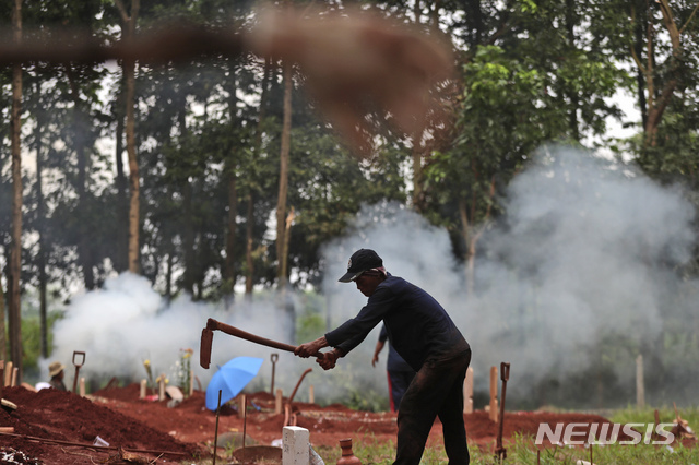 A gravedigger prepares a grave for a COVID-19 victim at Cipenjo cemetery in Bogor, West Java, Indonesia, Wednesday, July 14, 2021. The world&#039;s fourth most populous country has been hit hard by an explosion of COVID-19 cases that have strained hospitals on the main island of Java.(AP Photo/Achmad Ibrahim)