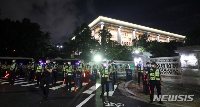 [서울=뉴시스] 추상철 기자 = '코로나19 대응 전국자영업자비상대책위원회'의 거리두기 4단계 조치 항의 심야 차량 시위가 예정된 14일 오후 서울 여의도 국회둔치주차장 인근 국회 게이트 앞에서 경찰 병력이 대기하고 있다. 2021.07.15. scchoo@newsis.com