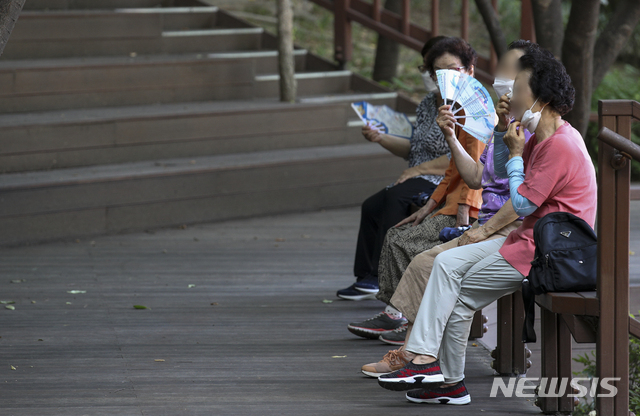 [서울=뉴시스] 정병혁 기자 = 폭염이 이어지고 있는 15일 오전 서울 중랑구 용마폭포공원을 찾은 시민들이 그늘에서 부채질을 하며 더위를 식히고 있다. 2021.07.15. jhope@newsis.com