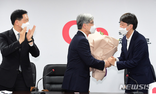 [서울=뉴시스] 국회사진기자단 = 이준석 국민의힘 대표가 15일 서울 여의도 국민의힘 중앙당사에서 입당 신청을 마친 최재형 전 감사원장에게 꽃다발을 전달하고 있다. 2021.07.15. photo@newsis.com