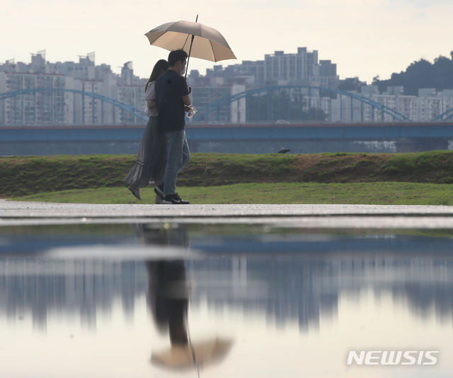 [서울=뉴시스] 조수정 기자 = 폭염 속 소나기가 내린 지난 15일 서울 서초구 반포지구 한강공원에서 시민들이 우산을 쓰고 걸어가고 있다. 2021.07.15. chocrystal@newsis.com