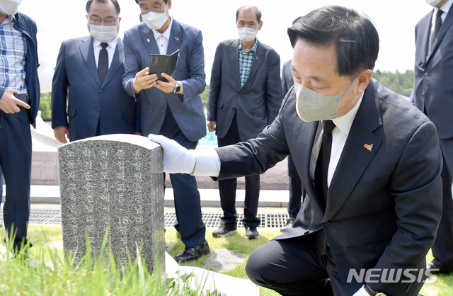 [광주=뉴시스] 류형근 기자 = 더불어민주당 대선 주자인 김두관 의원이 19일 오전 광주 북구 운정동 국립5·18민주묘지를 참배한 뒤 윤상원 열사 묘비를 보고 있다. 2021.07.19. hgryu77@newsis.com