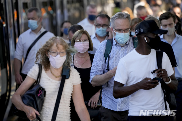 On what some have called &quot;Freedom Day&quot;, marking the end of coronavirus restrictions in England, commuters disembark from a train at London Bridge train station in London, during the morning rush hour, Monday, July 19, 2021. Beginning Monday, face masks will be recommended but not compulsory and with social distancing rules shelved, there will also be no more limits on people attending theater performances or big events. (AP Photo/Matt Dunham)