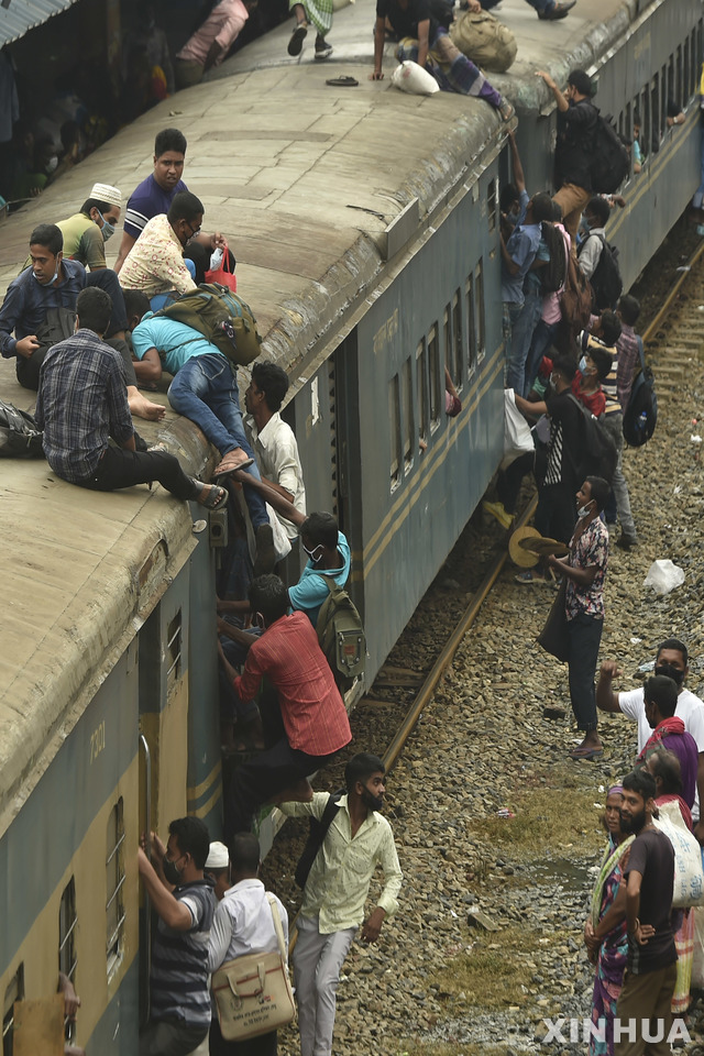 [다카=신화/뉴시스] 19일(현지시간) 방글라데시 다카에 있는 한 기차역에서 승객들이 만원 열차에 올라타고 있다. 이슬람 축제인 이드 알-아드하를 맞아 수십만 명의 다카 거주민이 고향에서 친지들과 축제를 함께 하기 위해 도시를 빠져나가고 있다. 2021.07.20.