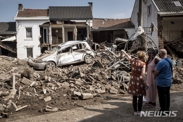 [리에주=AP/뉴시스] 지난 19일(현지시간) 벨기에 리에주에서 주민들이 침수로 파손된 차와 집을 살피고 있다. 2021.07.26.