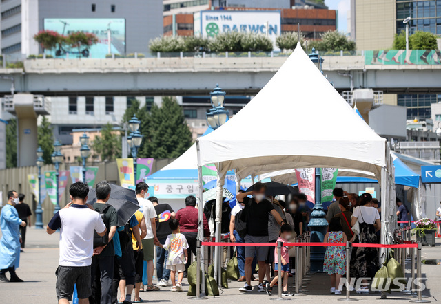 [서울=뉴시스] 김선웅 기자 = 전국 대부분 지역에 폭염 특보가 내려진 21일 오후 서울역광장 선별검사소에서 시민들이 검사를 받기 위해 우산을 쓰거나 천막 아래서 기다리고 있다 2021.07.21. mangusta@newsis.com