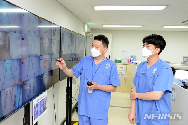 [서울=뉴시스]세브란스병원 의료진이 CCTV 모니터를 통해 생활치료센터 상황을 살펴보고 있다. (사진= 세브란스병원 제공) 2021.07.22