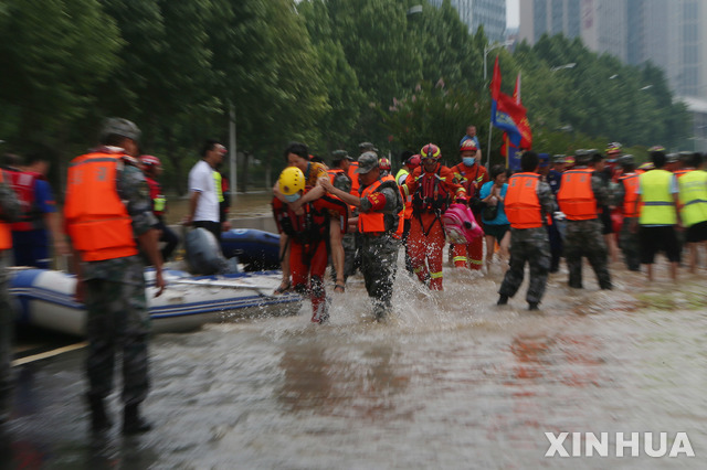 [정저우=신화/뉴시스] 최악의 폭우 사태로 큰 피해가 발생한 중국 허난성 성도 정저우의 중무현에서 22일 구조대원들이 침수에 직면한 병원에 있는 환자와 직원들을 긴급 대피시키고 있다. 2021.07.24 
