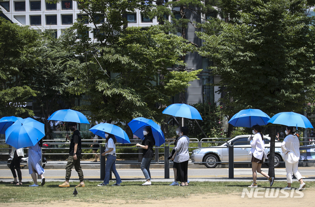 [서울=뉴시스] 정병혁 기자 = 폭염이 이어지고 있는 23일 오전 서울 용산구 용산역 광장에 설치된 임시선별검사소에서 시민들이 검사소에 비치된 파란색 우산을 쓴 채 검사를 위해 대기하고 있다. 2021.07.23. jhope@newsis.com