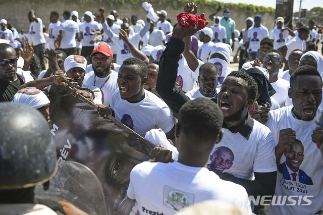[카프아이시앵(아이티)=AP/뉴시스] 암살된 조브넬 모이즈 아이티 대통령의 장례식이 23일(현지시간) 그의 고향인 카프아이시앵에서 치러졌다. 장례식장 밖에서 대통령 지지자들이 시위를 벌이면서 경찰과 충돌하고 있다. 2021.07.24 