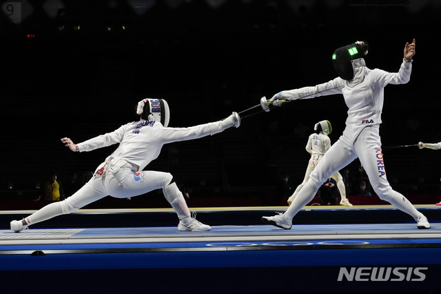 Aizanat Murtazaeva of the Russian Olympic Committee, left, and Choi Injeong of Korea compete in the women&#039;s individual Epee round of 32 competition at the 2020 Summer Olympics, Saturday, July 24, 2021, in Chiba, Japan. (AP Photo/Andrew Medichini)