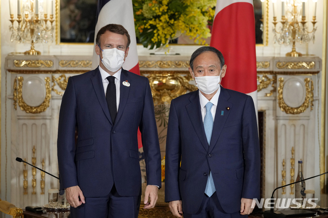 [도쿄=AP/뉴시스]스가 요시히데 일본 총리(오른쪽)와 에마뉘엘 마크롱 프랑스 대통령이 지난 24일 도쿄 모토아카사카 영빈관에서 정상회담을 앞두고 함께 포즈를 취하고 있다. 2021.07.27.