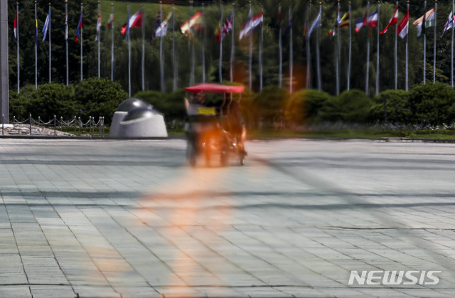 [서울=뉴시스] 정병혁 기자 = 폭염이 이어지고 있는 24일 오후 서울 송파구 올림픽공원 평화의문 성화 열기로 시민들의 모습이 일그러져 있다. 2021.07.24. jhope@newsis.com