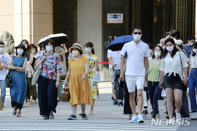 [도쿄=AP/뉴시스] 일본 수도 도쿄에서 24일 코로나19 예방을 위해 마스크를 착용한 시민들이 횡단보도를 건너고 있다. 2021.07.25 