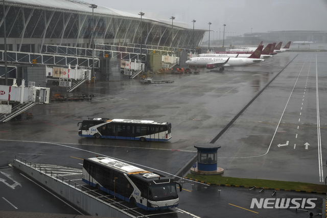 [상하이=AP/뉴시스]6호 태풍 인파의 상륙을 앞두고 모든 항공기 운항이 취소된 저장(浙江)성 상하이의 푸둥 국제공항에서 25일 발이 묶인 항공기와 버스들이 멈춰 서 있다. 2021.7.25