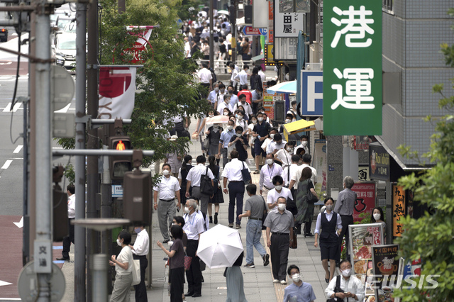 [도쿄=AP/뉴시스]지난 26일 도쿄올림픽 현수막이 걸린 일본 도쿄 하마마쓰조 거리에서 시민들이 걸어가고 있다. 2021.07.29.
