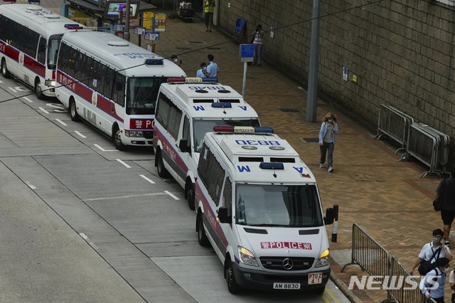[홍콩=AP/뉴시스] 27일 홍콩 경찰과 경찰 차량들이 보안법 기소 첫 유죄판결을 받은 퉁잉킷 피고인의 출정을 기다리고 있다 