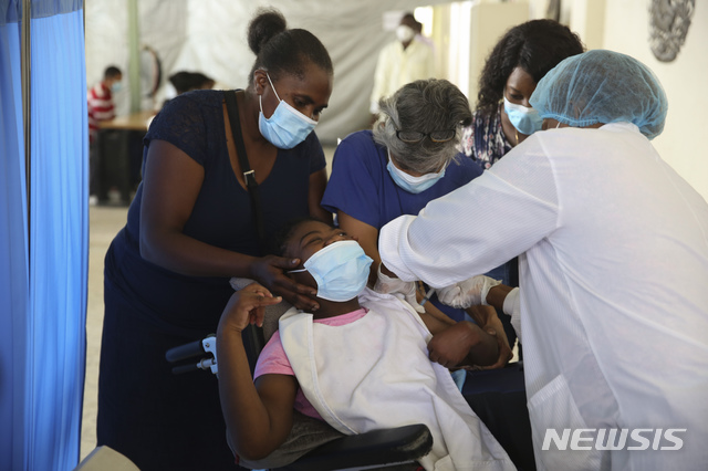 [포르토프랭스=AP/뉴시스] 27일(현지시간) 아이티 수도 포르토프랭스의 한 병원에서 의료진이 한 청소년에게 모더나 백신을 접종하고 있다. 아이티는 7월 중순 유엔 코백스(COVAX) 프로젝트를 통해 미국으로부터 백신 50만 도스를 기증받았다. 2021.07.28.