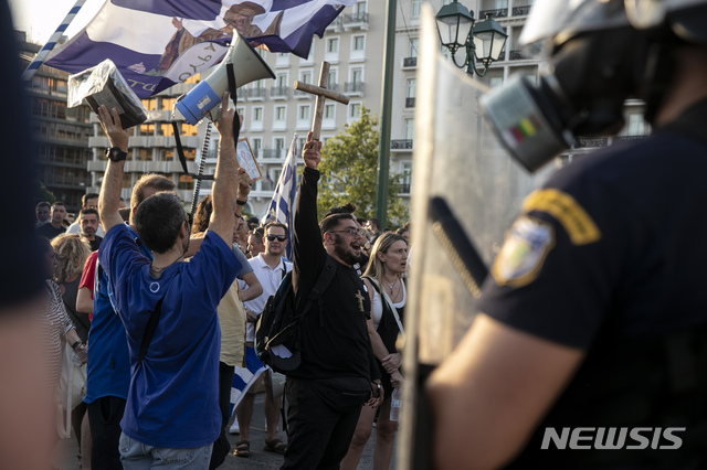 [아테네=AP/뉴시스] 7월28일 그리스 아테네의 신타그마 광장에서 백신에 반대하는 시위대가 경찰과 대치하고 있다. 이날 수백 명의 그리스 시민이 정부의 의료·보건 종사자의 백신 접종 의무화 등을 골자로 하는 '의무화' 법안에 반대하며 시위에 나섰다. 