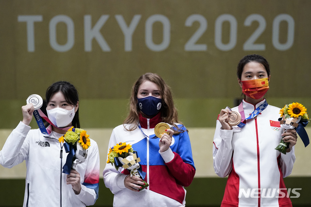 Silver medalist Minjung Kim, left, of South Korea, gold medalist Vitalina Batsarashkina, of the Russian Olympic Committee, and bronze medalist Xiao Jiaruixuan, of China, celebrate after the women&#039;s 25-meter pistol at the Asaka Shooting Range in the 2020 Summer Olympics, Friday, July 30, 2021, in Tokyo, Japan. (AP Photo/Alex Brandon)