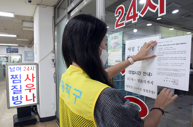 [서울=뉴시스] 동작구청 관계자가 4일 서울 동작구 노량진동의 한 사우나 업소에서 코로나19 4차 확산방지를 위해 관내 다중이용시설 이·미용업, 목욕장업 ,실내체육시설, 고시원 등 1663개소 운영자 및 종사자(코로나19 예방접종완료자 포함) 등 코로나19 진단검사 행정명령서를 출입문에 부착 하고 있다. (사진=동작구 제공) 2021.08.04. photo@newsis.com *재판매 및 DB 금지