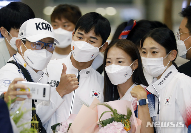 [인천공항=뉴시스] 고승민 기자 = 근대5종 전웅태와 마라톤 선수단이 9일 인천국제공항 2터미널을 통해 귀국, 기념촬영을 하고 있다. 2021.08.09. kkssmm99@newsis.com