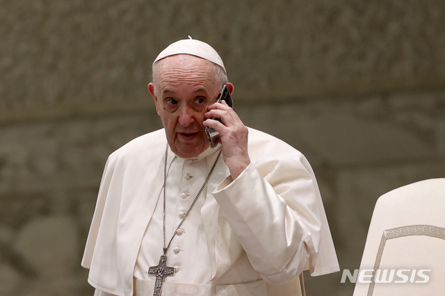 [바티칸=AP/뉴시스]프란치스코 교황이 11일 일반 알현 도중 보좌관으로부터 휴대전화를 건네받고 통화하고 있다. 2021.8.11.