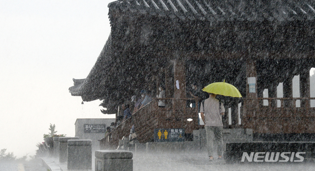 [전주=뉴시스] 김얼 기자 = 전북 전주시에 갑작스러운 집중호우가 내리기 시작한 지난 12일 오후 전주한옥마을 남천교 청연루 처마 밑에서 관광객들이 비를 피하고 있다. 2021.08.12. pmkeul@newsis.com