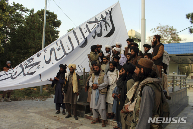 [가즈니(아프가니스탄)=AP/뉴시스] 탈레반 전사들이 15일(현지시간) 아프가니스탄 가즈니 주지사 관저에서 탈레반기를 게양하기 앞서 기념촬영을 하고 있다. 2021.08.17.