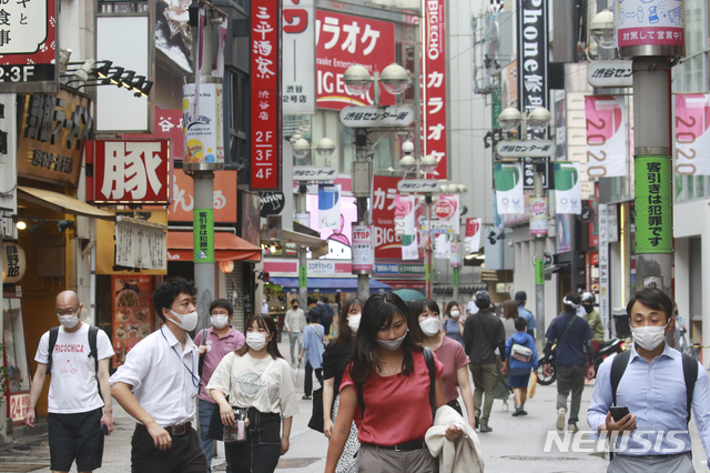 [도쿄=AP/뉴시스]17일 일본 도쿄의 한 거리를 코로나19 감염 예방을 위해 마스크를 쓴 시민들이 지나가고 있다. 2021.08.17