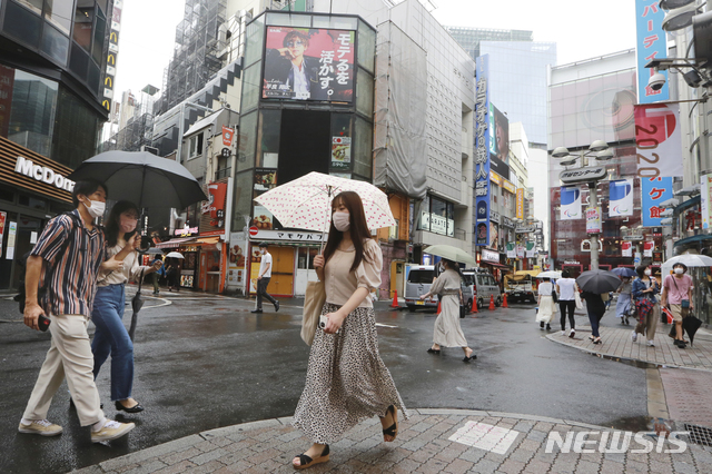 [도쿄=AP/뉴시스] 일본 수도 도쿄 시내에서 17일 코로나19 예방을 위해 마스크를 착용한 시민들이 비오는 거리를 지나가고 있다. 2021.08.17 