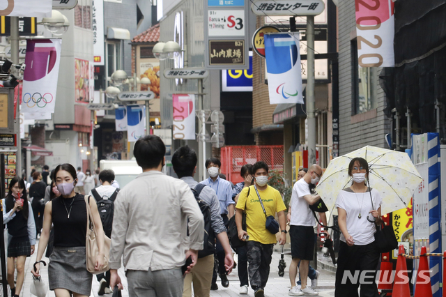 [도쿄(일본)=AP/뉴시스]지난 17일 일본 도쿄의 한 거리에서 코로나19 감염 예방을 위해 마스크를 쓴 시민들이 걸어가고 있다. 2021.08.18.