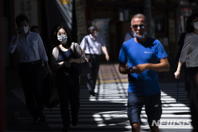 [도쿄=AP/뉴시스] 19일 일본 도쿄의 한 교차로에서 코로나19 확산 방지를 위해 마스크를 쓴 시민들이 걸어가고 있다. 오는 24일 개막하는 도쿄 장애인올림픽(패럴림픽)과 관련해 대회 관계자 등 16명이 코로나19에 신규 감염돼 지금까지 패럴림픽 관련 코로나19 확진자는 총 74명으로 늘었다. 2021.08.19.