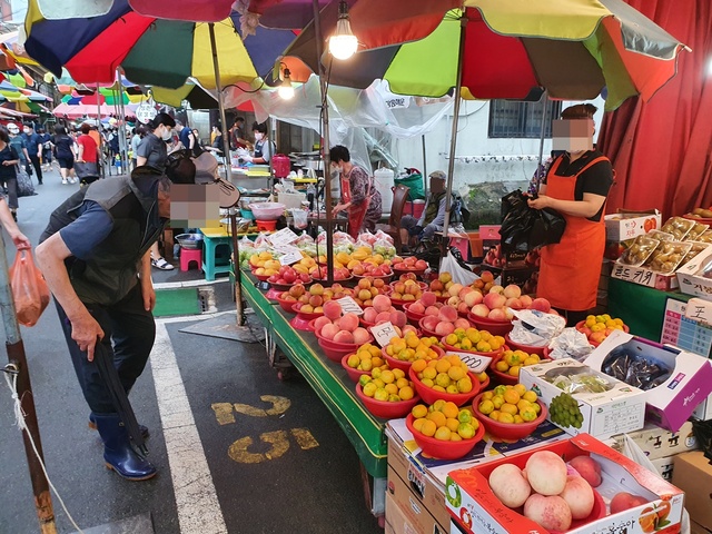 [울산=뉴시스] 구미현 기자 = 태풍 오마이스의 영향으로 수해를 입었던 울산 중구 태화시장이 25일 복구를 마치고 다시 문을 열었다. 5일 장을 찾은 한 시민이 과일 장을 보고 있다. 2021.08.25. (사진=울산시 중구 제공) photo@newsis.com *재판매 및 DB 금지