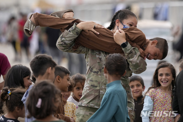 [람스타인=AP/뉴시스] 24일(현지시간) 독일 람스타인 미 공군기지에서 한 미군 병사가 최근 도착한 아프가니스탄 대피 어린이들과 놀아주고 있다. 탈레반은 미군 철수 시한을 연장할 수 없다고 재차 밝히면서 현지인들이 아프간 탈출을 위해 카불 공항에 가는 것을 더는 허락하지 않겠다고 경고했다. 2021.08.25.
