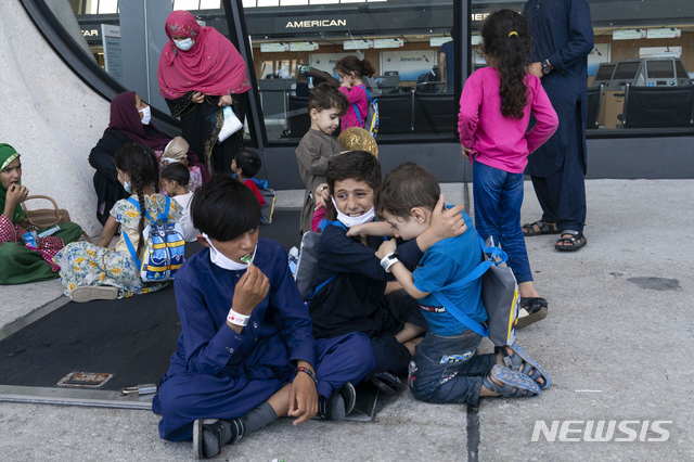 [챈틸리=AP/뉴시스] 아프가니스탄 카불에서 가족과 함께 대피한 아프간 어린이들이 24일(현지시간) 미 버지니아주 챈틸리의 덜레스 국제공항에 도착해 버스를 기다리며 바닥에 앉아 있다. 탈레반은 미군 철수 시한을 연장할 수 없다고 재차 밝히면서 현지인들이 아프간 탈출을 위해 카불 공항에 가는 것을 더는 허락하지 않겠다고 경고했다. 카불 공항에서는 미국과 동맹국들이 아프간 내 자국민과 각국에 협력한 현지인들을 대피시키고 있다. 2021.08.25.
