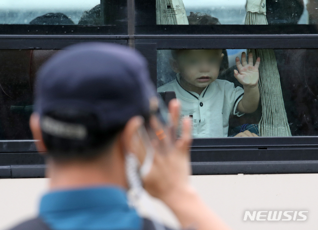 [김포=뉴시스] 조성우 기자 = 아프가니스탄 현지인 조력자 가족 아이가 27일 오전 경기도의 한 임시 숙소에서 나와 충북 진천의 공무원인재개발원으로 이동하는 버스에 타 경찰과 손인사를 하고 있다. 2021.08.27. xconfind@newsis.com