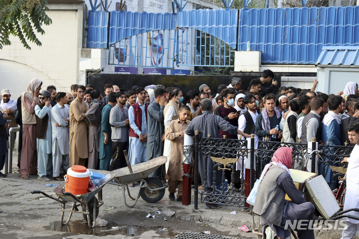 [카불(아프가니스탄)=AP/뉴시스]아프가니스탄 카불 주민들이 은행 앞에서 돈을 인출하기 위해 긴 줄을 서서 대기 중이다. 2021.08.31.photo@newsis.com