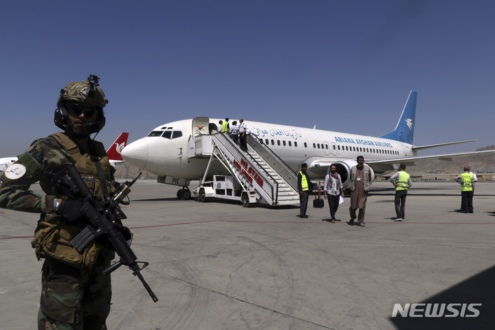 [카불(아프가니스탄)=AP/뉴시스]5일(현지시간) 아프가니스탄 카불의 하미드 카르자이 국제공항에 승객들이 도착하자 탈레반 병사들이 경비를 서고 있다. 2021.09.05.photo@newsis.com