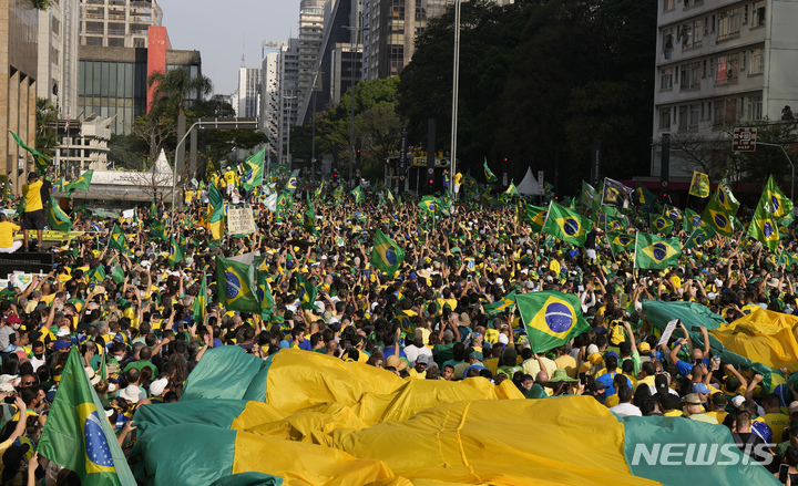 [상파울루= AP/뉴시스]브라질 상파울루의 보우소나루 지지 시위대가 지난 해 9월 7일 중심가 도로를 메우고 행진하고 있다.