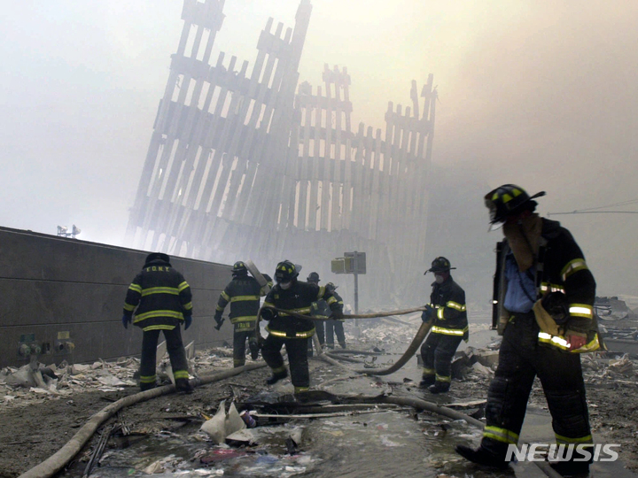 [뉴욕=AP/뉴시스] 2001년 9월 11일 미국 뉴욕 세계무역센터 인근에서 소방관들이 화재진압을 하고 있다. 2021.09.10.