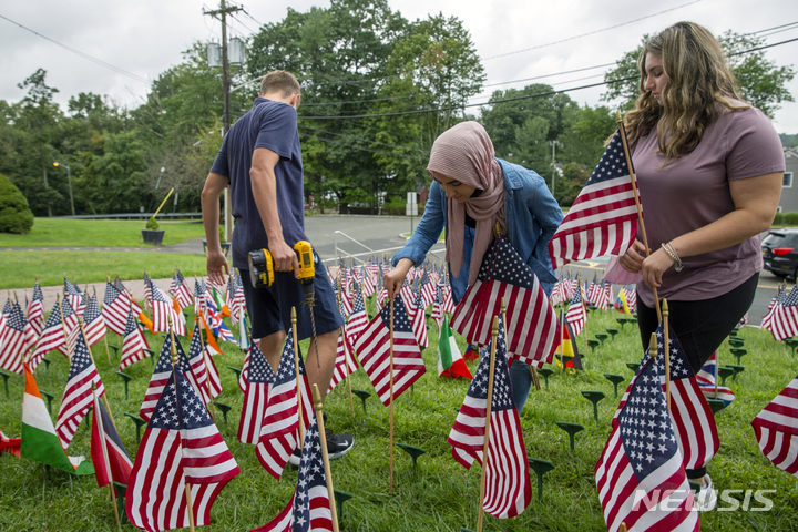 [시더그로브=AP/뉴시스]지난 9일 뉴저지 시더그로브 고등학교 학생들이 9·11 테러 희생자를 기리는 의미로 미국 국기를 설치하는 모습. 2021.09.11.