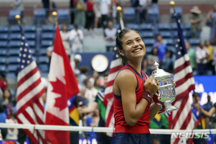 [뉴욕=AP/뉴시스]여자 테니스에 10대 돌풍을 일으킨 영국의 엠마 라두카누(18)가 캐나다의 레일라 페르난데스(19)를 누르고 US오픈 테니스 여자 단식 우승을 차지한 후 트로피를 들고 기뻐하고 있다. 2021.09.13