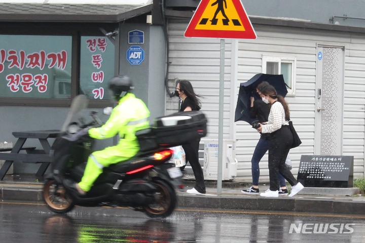 [제주=뉴시스] 양영전 기자 = 제주시 건입동 거리에서 한 시민이 흔들리는 우산을 붙잡고 있다. (뉴시스DB) 0jeoni@newsis.com