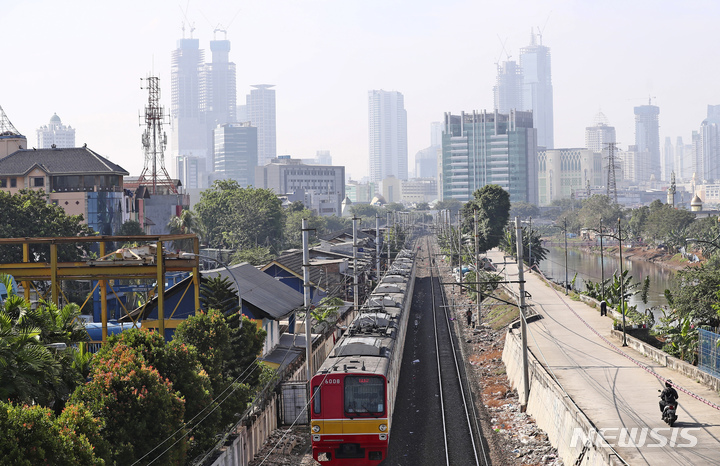 [자카르타(인도네시아)=AP/뉴시스]인도네시아 수도 자카르타에서 16일 흐릿한 도시 스카이라인을 배경으로 열차가 선로를 따라 운행하고 있다. 인도네시아 법원은 16일 조코 위도도 대통령을 비롯한 6명의 고위 관리들이 청정한 공기를 마실 시민들의 권리를 충족시키지 못하고 있다며 수도 자카르타의 공기 질 개선을 명령했다. 2021.9.16