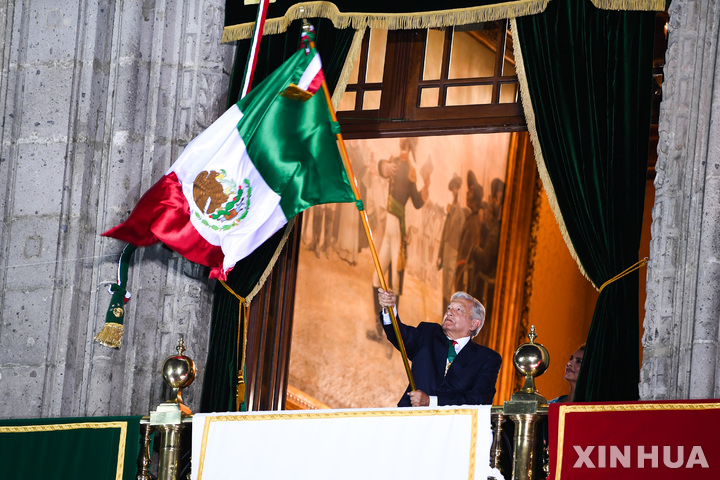 [ 멕시코시티=신화/뉴시스] 9월15일 멕시코 독립기념일 축하행사에서 연설을 앞두고 국기를 휘두르는 로페스 오브라도르 멕시코 대통령.  