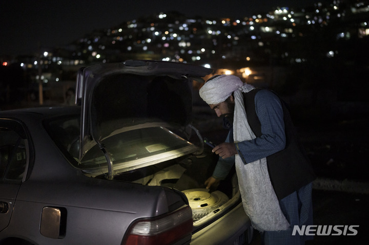 [카불=AP/뉴시스] 16일(현지시간) 아프가니스탄 카불의 한 검문소에서 탈레반 병사가 자동차 짐칸을 조사하고 있다. 2021.09.17.
