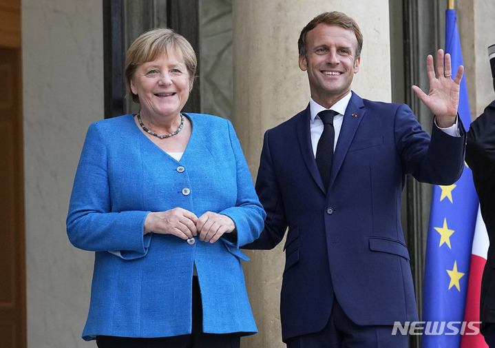 [파리=AP/뉴시스] 에마뉘엘 마크롱(오른쪽) 프랑스 대통령이 16일(현지시간) 파리 엘리제궁을 방문한 앙겔라 메르켈 독일 총리를 환영하고 있다. 2021.09.17.