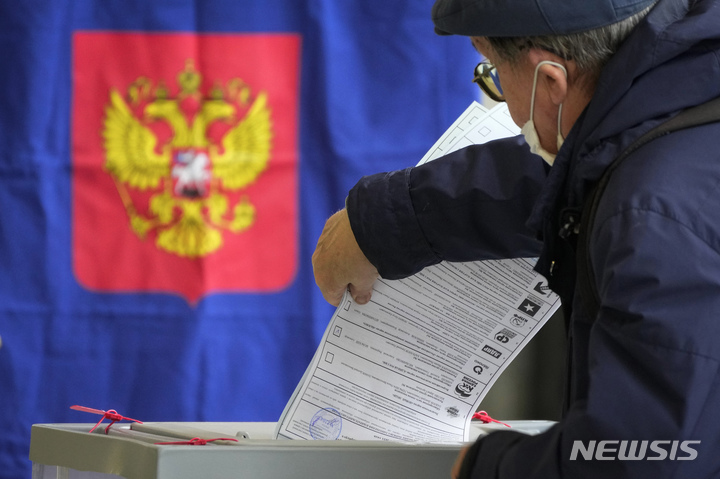 [상트페테르부르크(러시아)=AP/뉴시스] 러시아 연방 하원 선거 이틀 차인 18일(현지시간) 제2 도시 상트페테르부르크에서 한 유권자가 투표함에 용지를 넣고 있다. 2021.09.19.