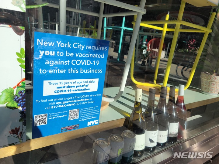 [뉴욕=뉴시스]지난 9월20일 미 뉴욕시 한 상점 유리창에 코로나19 백신 접종 증명 관련 안내문이 붙어 있다. 뉴욕시는 지난 13일부터 식당과 체육과 등 실내 시설 이용시 코로나19 백신 접종 증명을 의무화했다. 2021.09.20.